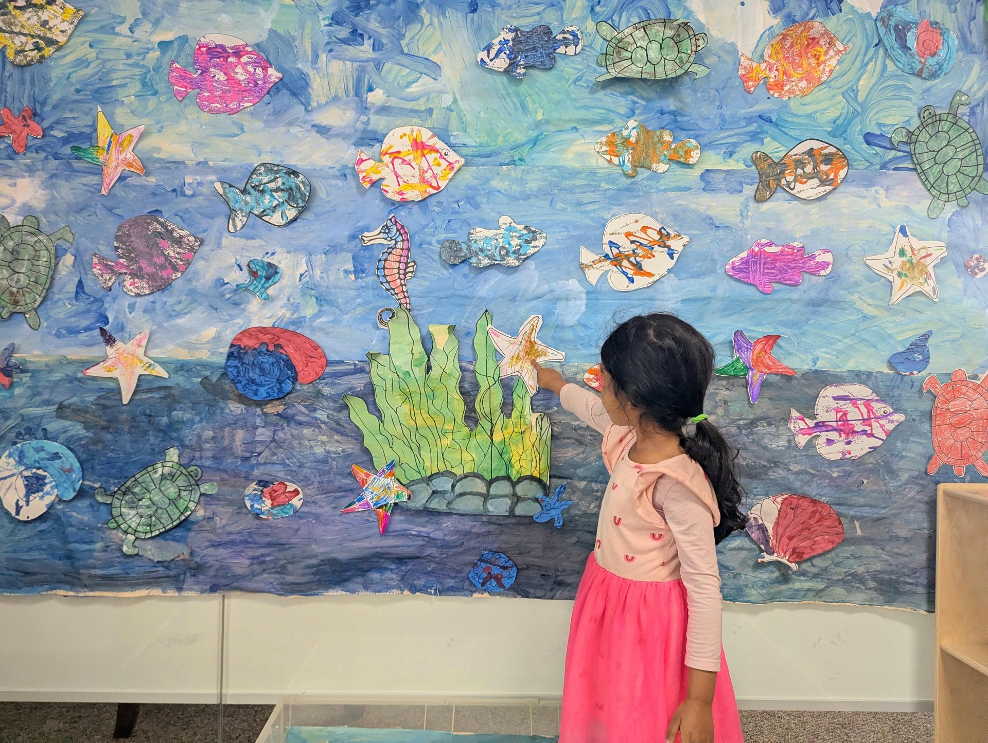 Child admiring an ocean mural at the school